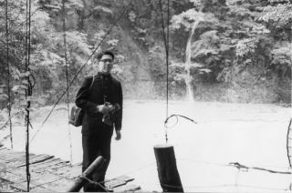 濁流に飲み込まれそうな湯の平温泉前の吊り橋と若き日の按針亭管理人(1961-10-28)